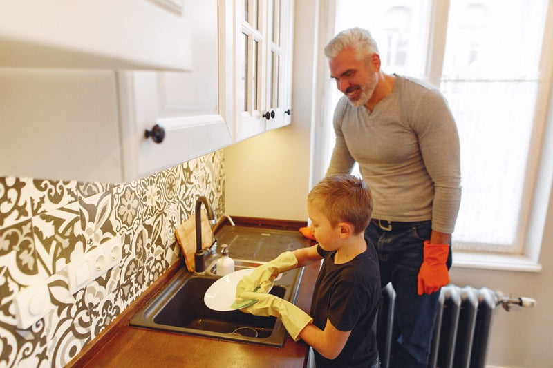 Father and child washing dishes together
